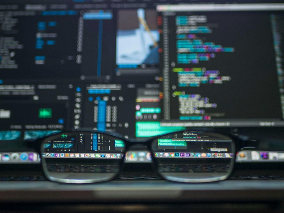 Vue à travers des lunettes avec du code informatique en arrière-plan