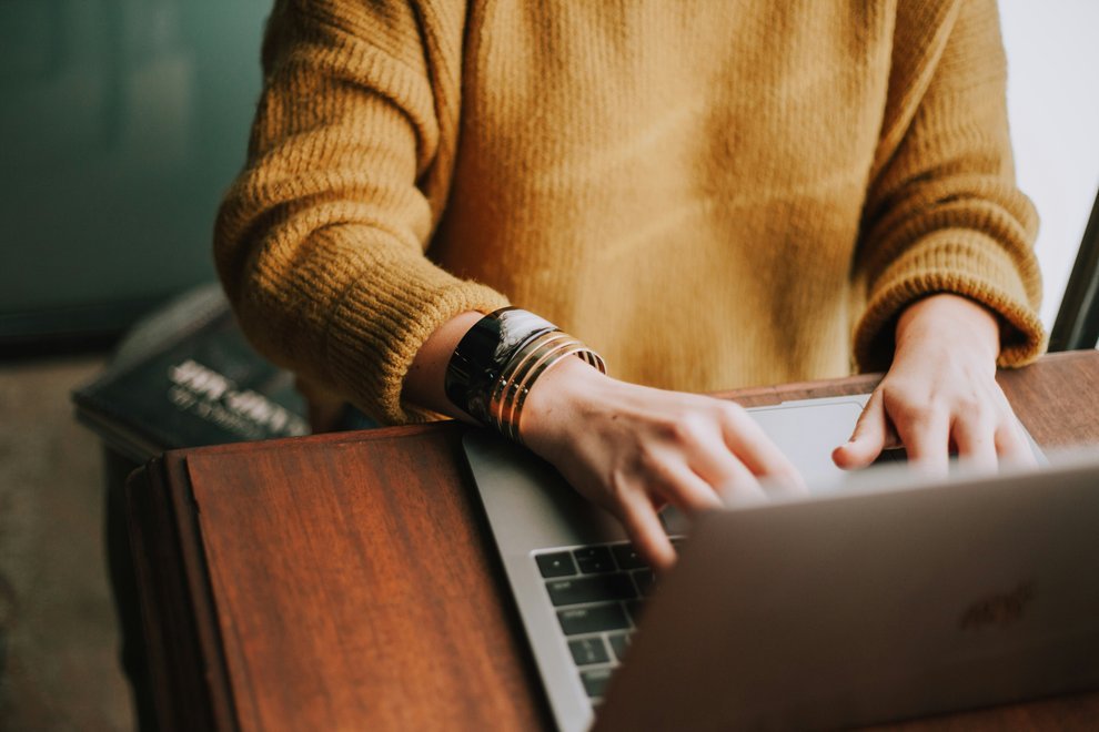 Une femme utilise son ordinateur portable, les doigts sur le clavier