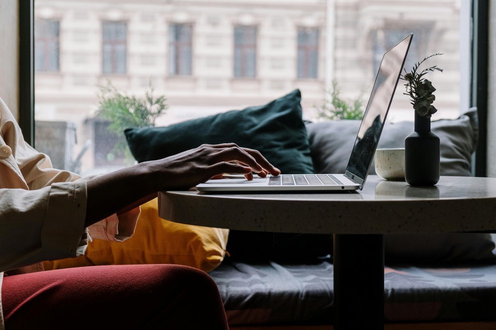 Les mains d'une femme sur le clavier d'un ordinateur portable.