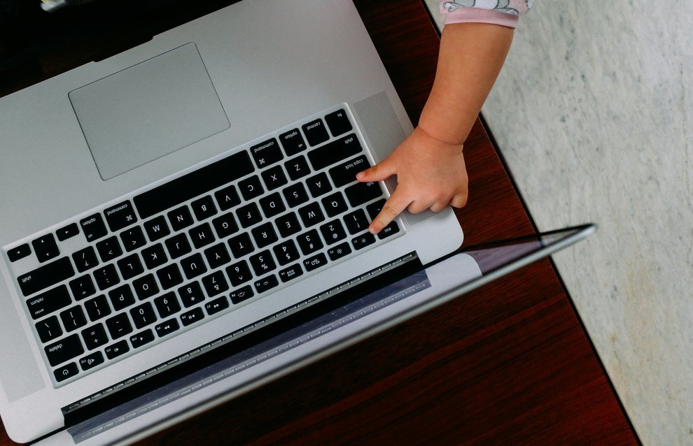 La main d'un bébé sur le clavier d'un ordinateur portable.