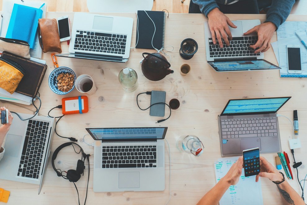 Une équipe travaillant avec leurs ordinateurs portables autour d'une table